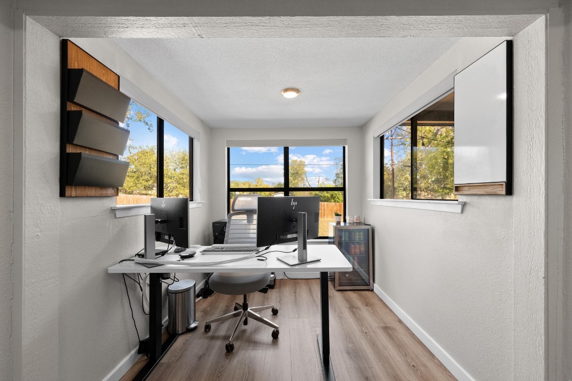 1006 Hollybluff Street Austin, TX 78753 - Photo 11 of 27 Office with light wood finished floors, a textured wall, plenty of natural light, and a textured ceiling