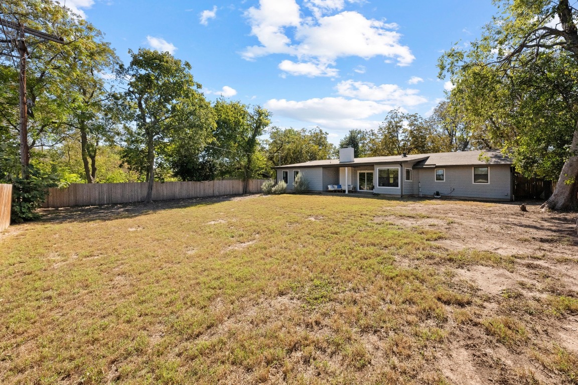 1006 Hollybluff Street Austin, TX 78753 - Photo 24 of 27 Rear view of house with a fenced backyard, a patio area, and a chimney