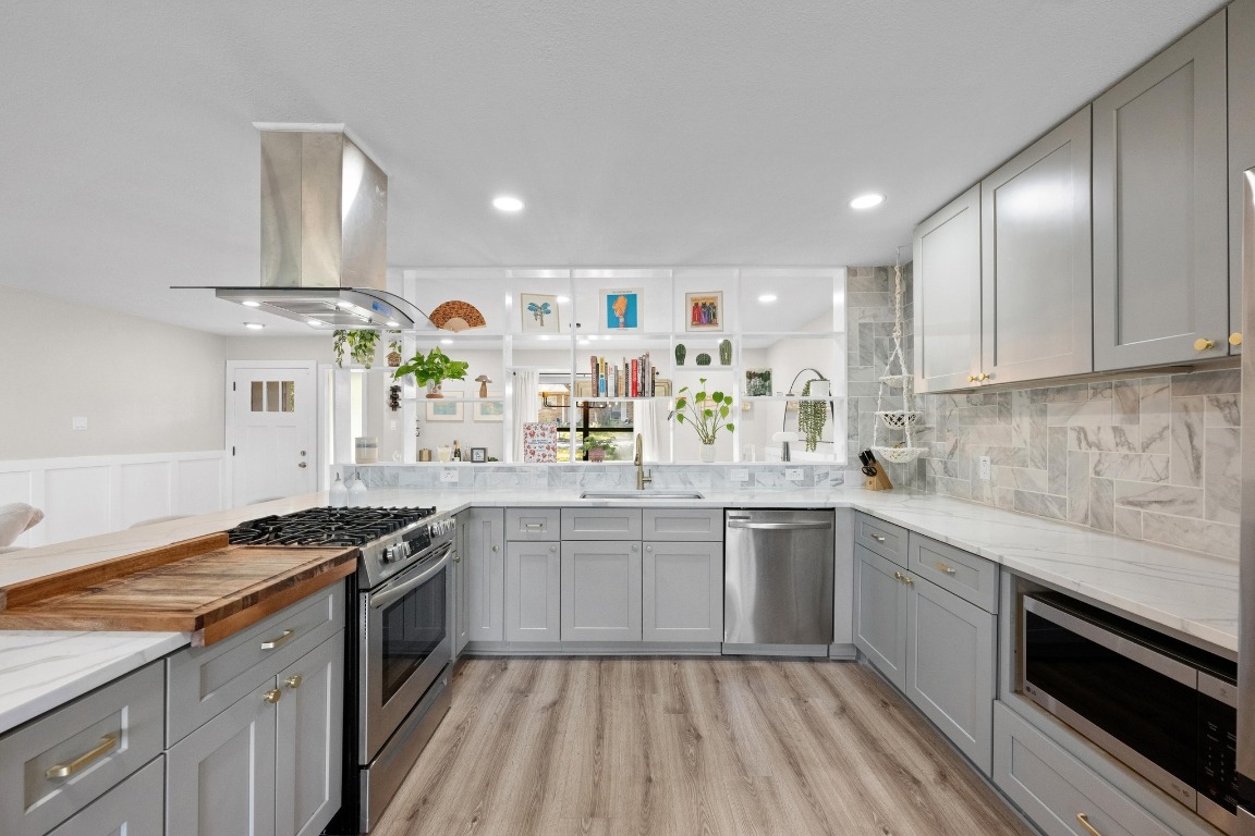 1006 Hollybluff Street Austin, TX 78753 - Photo 9 of 27 Kitchen featuring gray cabinets, stainless steel appliances, light wood-type flooring, island exhaust hood, and recessed lighting