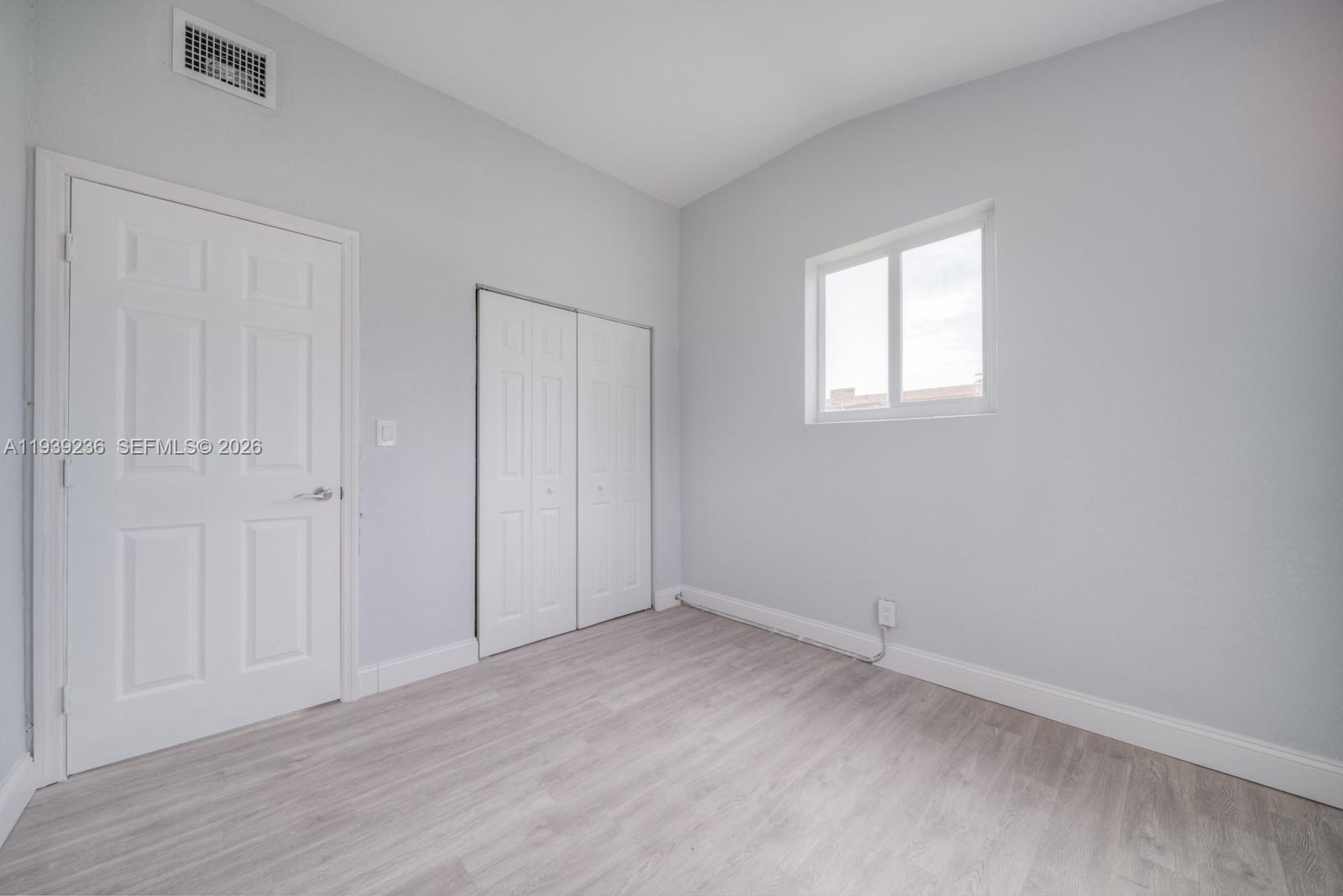 10290 Southwest 177th Street, Unit 10290 Miami, FL 33157 - Photo 11 of 16 an empty room with wooden floor and closet area