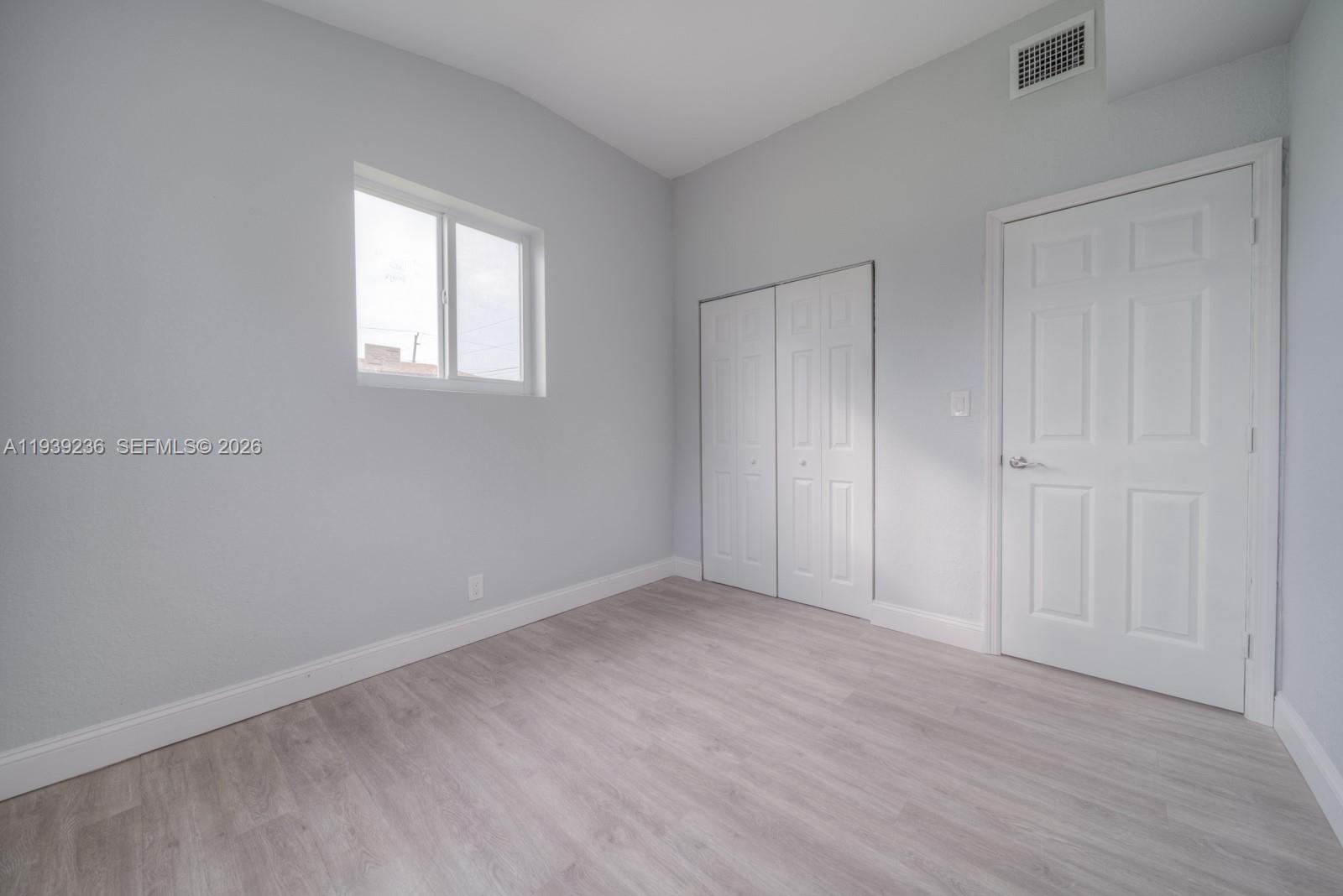 10290 Southwest 177th Street, Unit 10290 Miami, FL 33157 - Photo 13 of 16 an empty room with wooden floor and windows