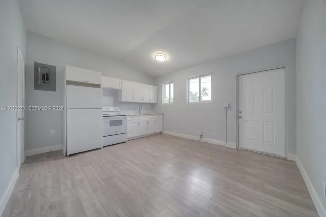 a view of a kitchen with white cabinets and wooden floor