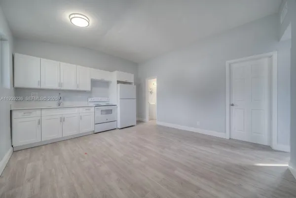 a kitchen with white cabinets and white appliances