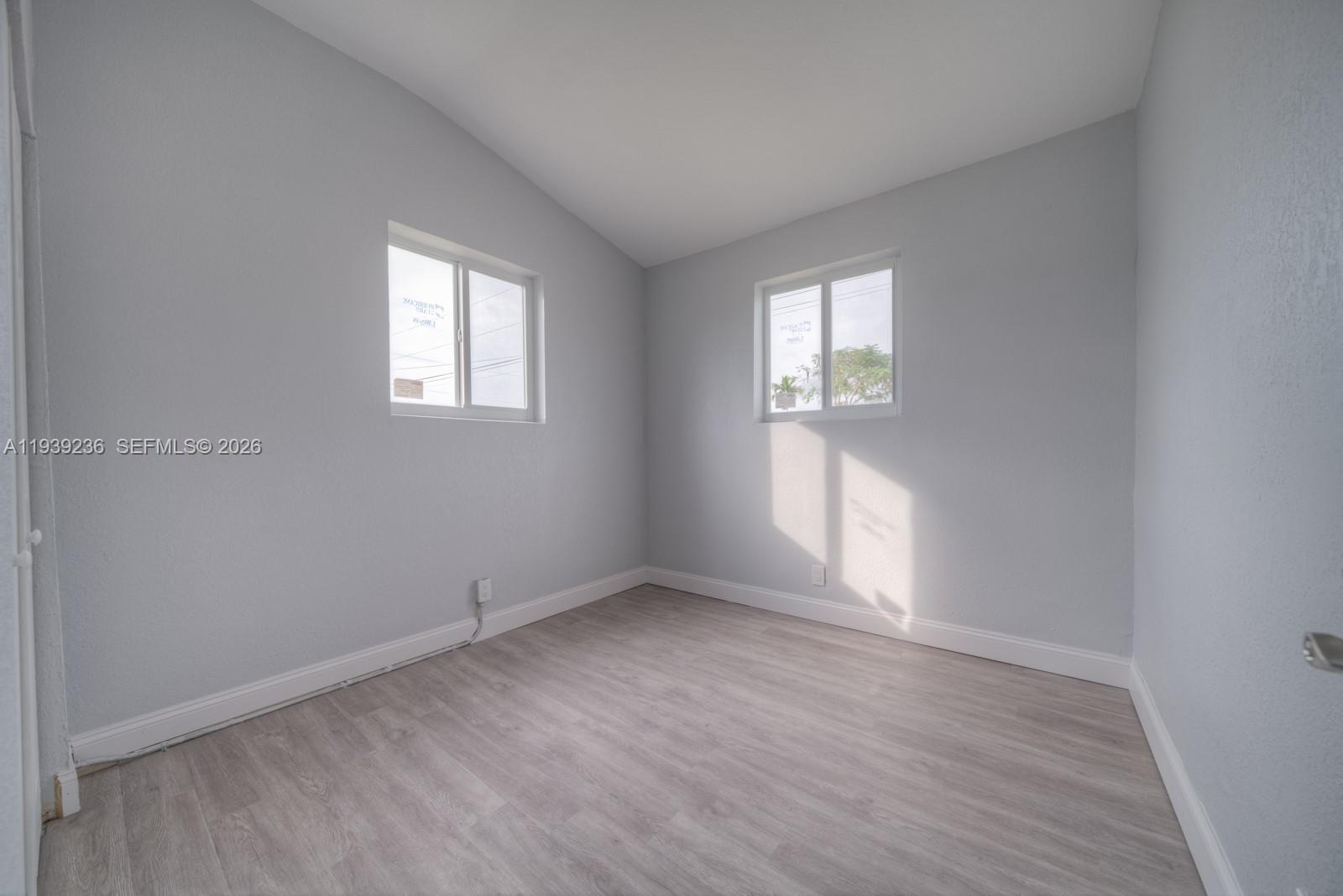 10290 Southwest 177th Street, Unit 10290 Miami, FL 33157 - Photo 10 of 16 an empty room with wooden floor and windows
