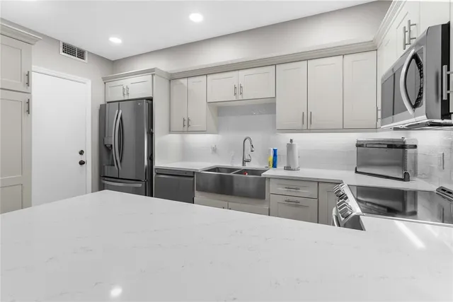 a kitchen with stainless steel appliances granite countertop a refrigerator stove and sink