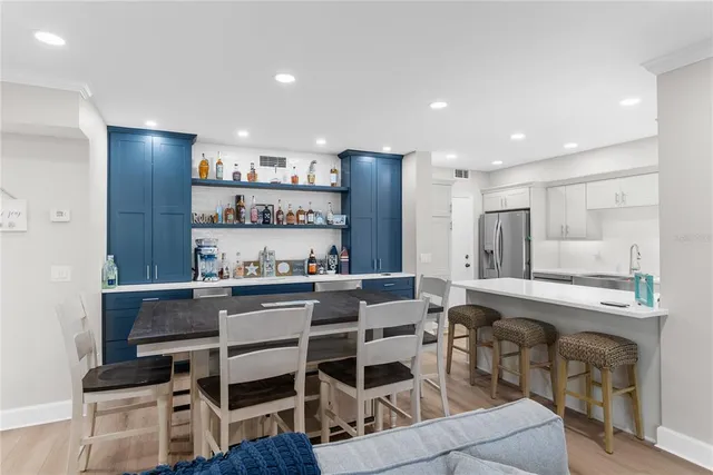 a kitchen with stainless steel appliances kitchen island granite countertop a table and chairs in it