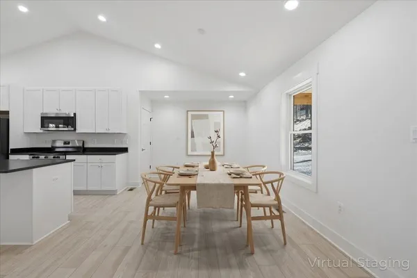 a kitchen with granite countertop white cabinets and black appliances