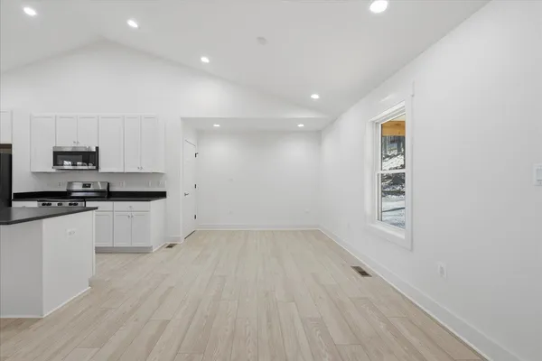 a kitchen with kitchen island granite countertop a sink stainless steel appliances and cabinets