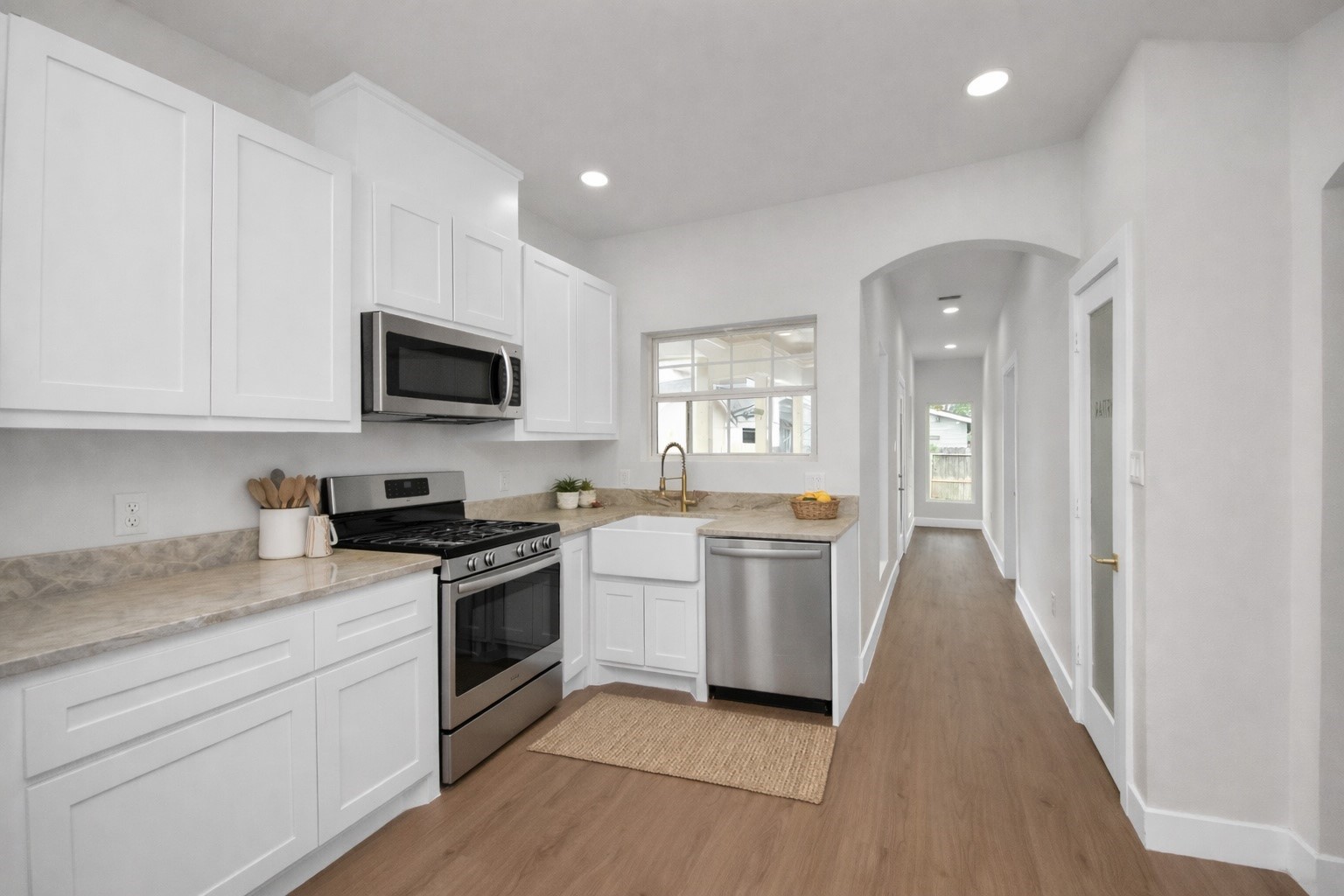 427 North Milby Street Houston, TX 77003 - Photo 12 of 44 Clean, modern kitchen with custom cabinetry, quartz countertops, and a farmhouse sink. Bright layout offers ample storage and functional design. Sleek finishes make this space both stylish and practical.