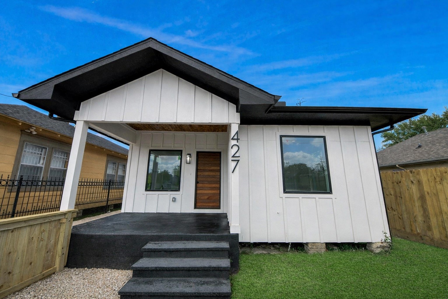 427 North Milby Street Houston, TX 77003 - Photo 36 of 44 Inviting covered front porch with modern finishes and a bold wood entry door. Fresh landscaping and private fencing create great curb appeal and a welcoming first impression. Perfect spot to relax and enjoy the neighborhood.