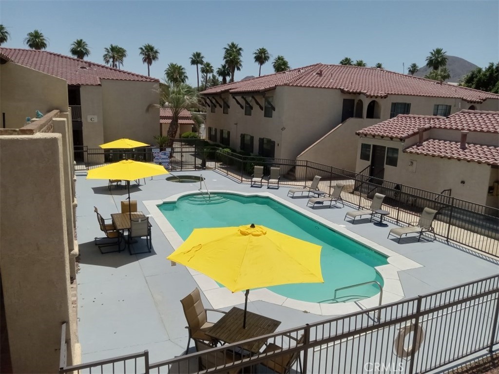 45200 Deep Canyon Road Palm Desert, CA 92260 - Photo 12 of 14 a view of a swimming pool with a table and chairs under an umbrella