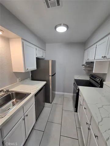 a kitchen with a stove cabinets and a refrigerator