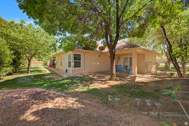 3034 Swiss Drive Santa Clara, UT 84765 - Photo 36 of 59 Expansive backyard featuring mature trees, a manicured lawn, and a concrete patio