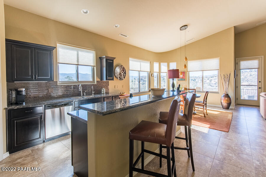1594 Rustling Wind Place Prescott, AZ 86301 - Photo 16 of 47 a kitchen with stainless steel appliances granite countertop table chairs sink and cabinets