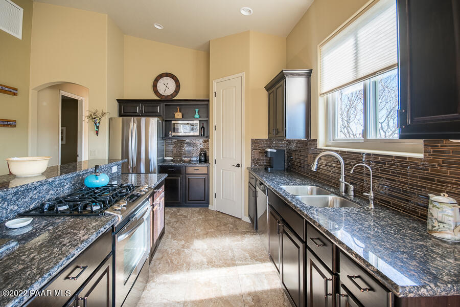 1594 Rustling Wind Place Prescott, AZ 86301 - Photo 17 of 47 a kitchen with stainless steel appliances granite countertop a sink stove and refrigerator