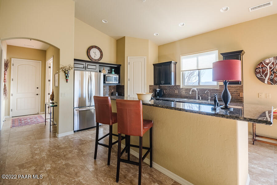 1594 Rustling Wind Place Prescott, AZ 86301 - Photo 18 of 47 a kitchen with stainless steel appliances granite countertop a refrigerator and a stove top oven