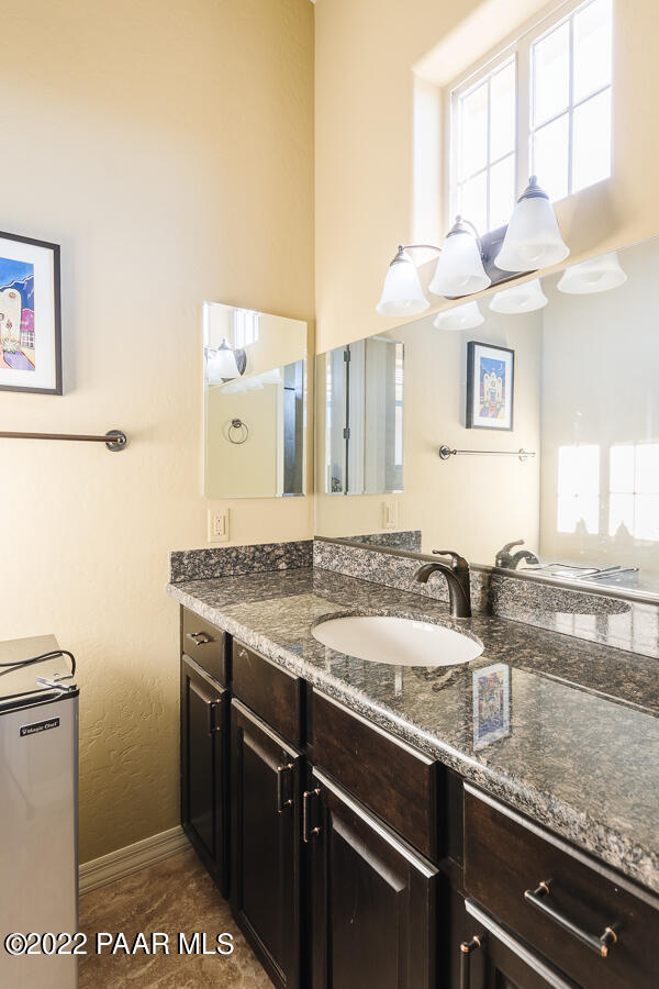 1594 Rustling Wind Place Prescott, AZ 86301 - Photo 40 of 47 a bathroom with a granite countertop sink a toilet and a mirror