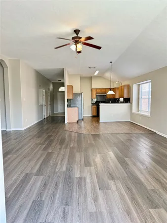 a view of a room with a wooden floor and ceiling fan