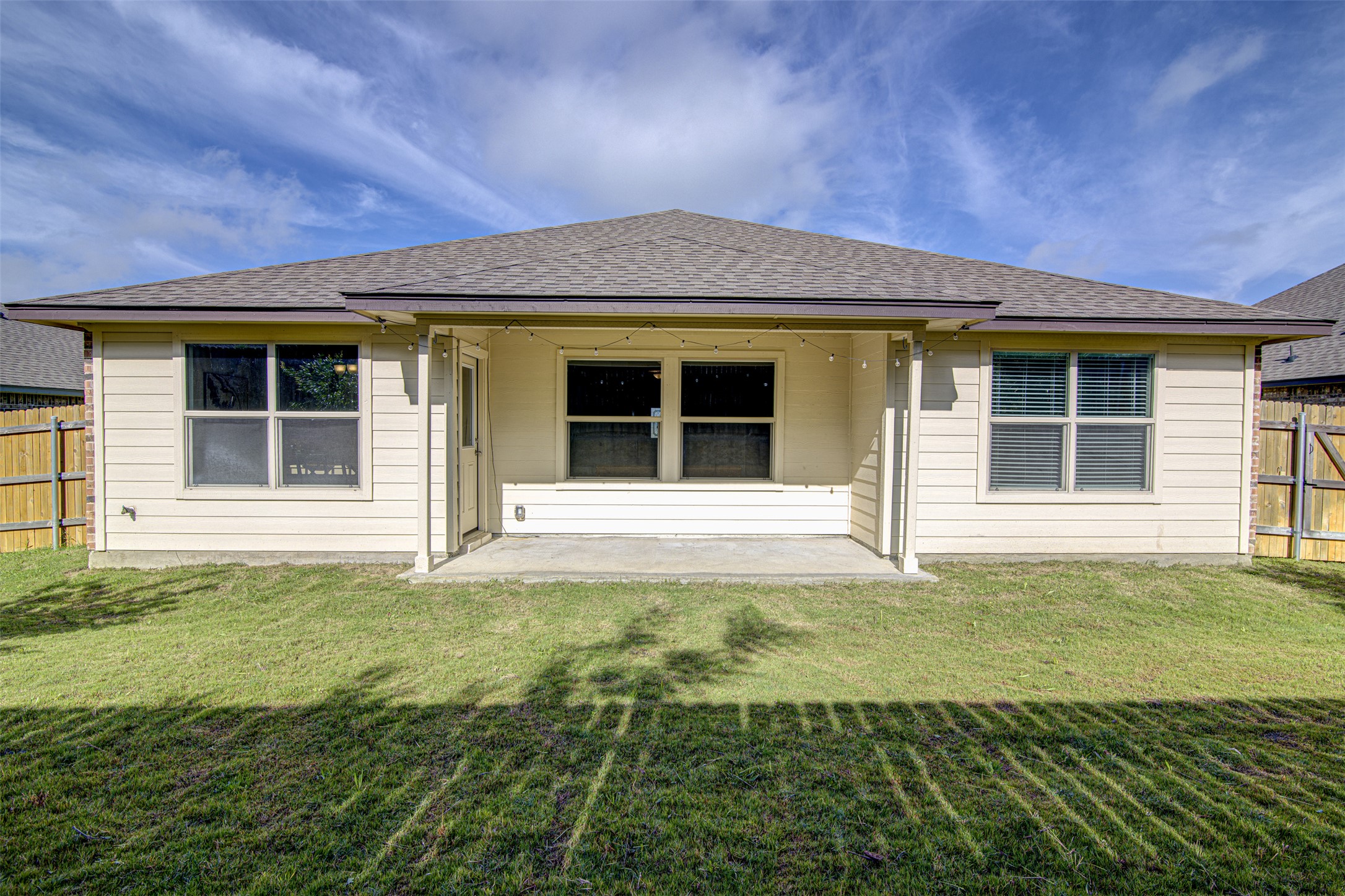316 Pepper Mill Loop Burnet, TX 78611 - Photo 24 of 27 A well-maintained lawn stretches to a private, covered patio, offering a secluded outdoor retreat.