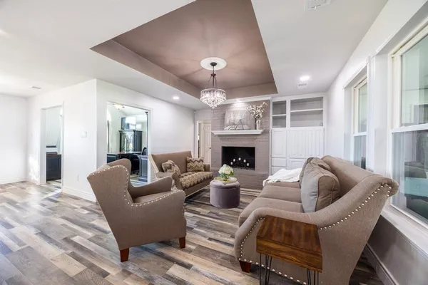 a living room with furniture fireplace and a large window