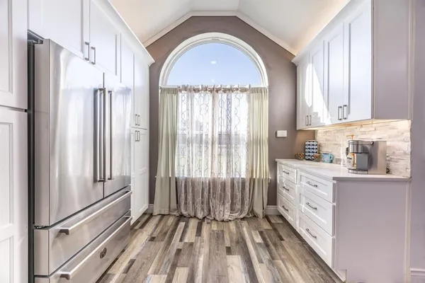 a view of a kitchen with a sink refrigerator and wooden floor