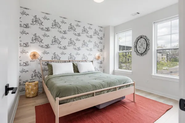 a kitchen with stainless steel appliances granite countertop a stove a sink a refrigerator a microwave a dining table and chairs with wooden floor