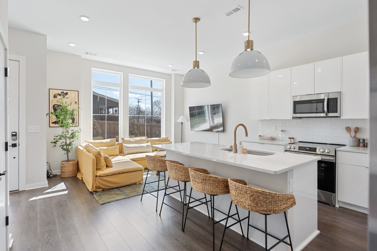 1233 Lischey Avenue Nashville, TN 37207 - Photo 32 of 89 a kitchen with stainless steel appliances granite countertop a stove a sink a refrigerator a microwave a dining table and chairs with wooden floor