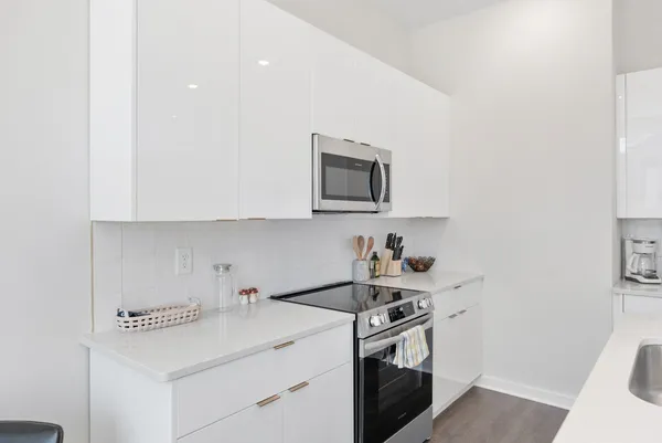 a kitchen with cabinets a sink stainless steel appliances and a window