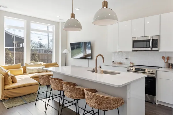 a kitchen with stainless steel appliances kitchen island granite countertop a sink a stove and a refrigerator