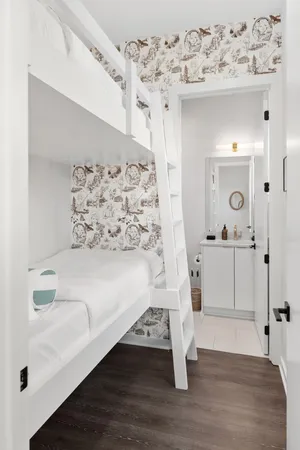 a kitchen with granite countertop a sink a stove a kitchen island with chairs and white cabinets