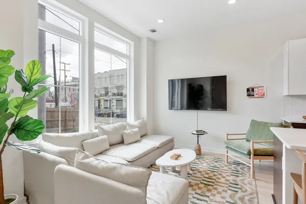 a kitchen with stainless steel appliances kitchen island granite countertop a table chairs sink and microwave