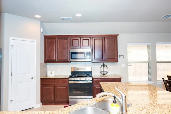 a kitchen with stainless steel appliances granite countertop a stove top oven a sink and dishwasher