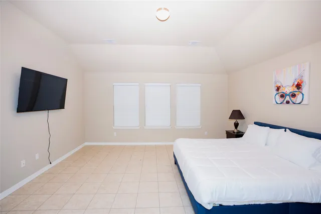 a bedroom with a bed and a flat screen tv