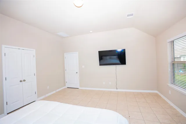 a bedroom with a bed and a flat screen tv