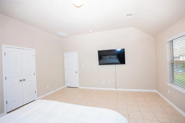 a bedroom with a bed and a flat screen tv
