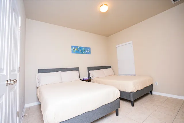 a bedroom with two beds and painting on the wall