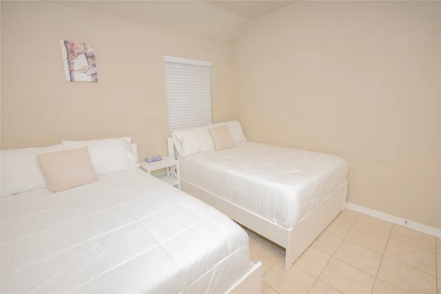 a bedroom with two beds and a night stand