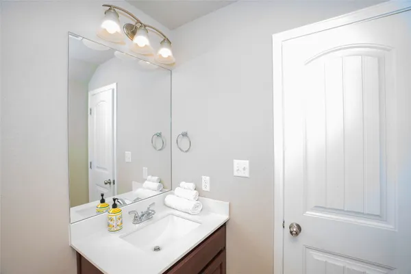 a bathroom with a sink a mirror and a vanity