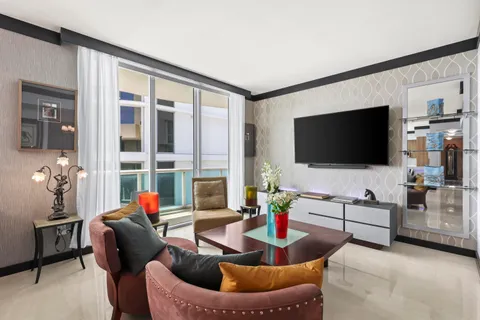 a living room with furniture kitchen view and large windows