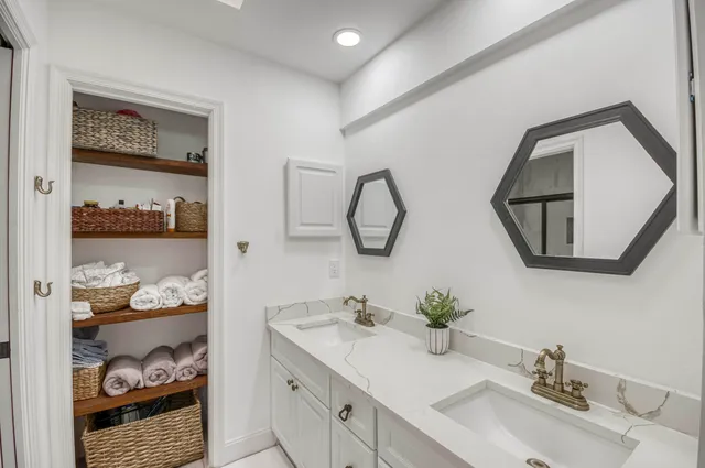 a bathroom with double vanity sinks and a mirror