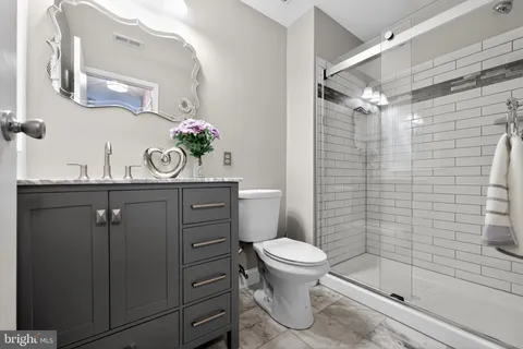 a bathroom with a sink a toilet and shower
