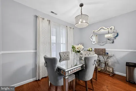 a dining room with furniture wooden floor and a chandelier