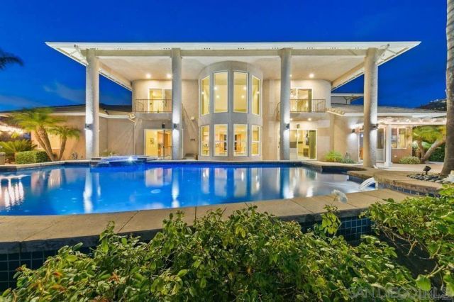 a living room with furniture a chandelier and a floor to ceiling window