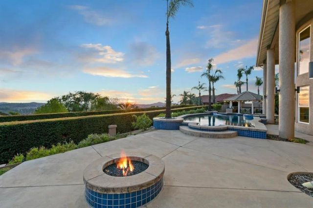 an aerial view of a house with swimming pool and large trees