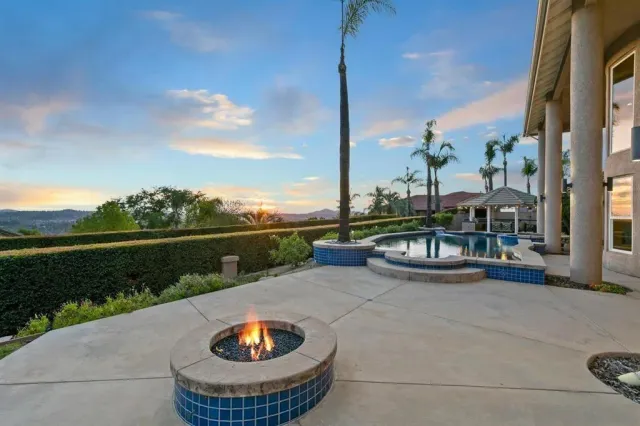 an aerial view of a house with swimming pool and large trees