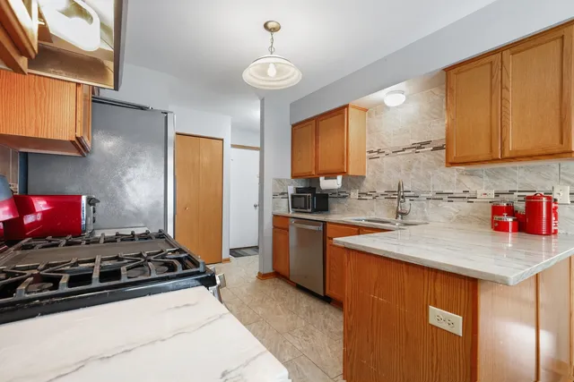 a kitchen with stainless steel appliances a stove a sink and a refrigerator