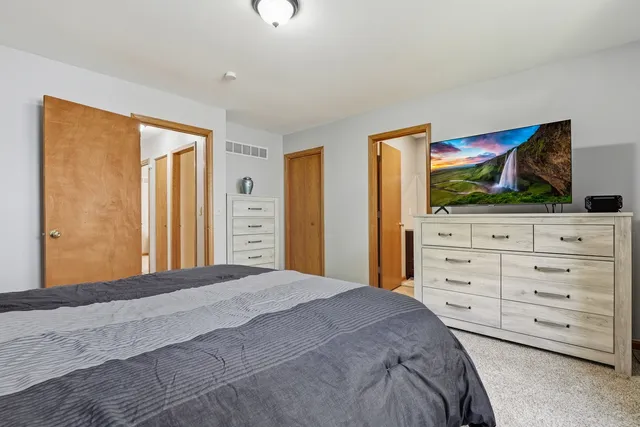 a bedroom with a bed and a flat screen tv