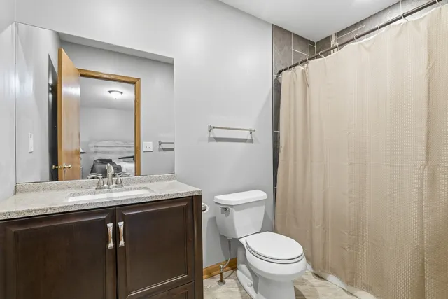 a bathroom with a granite countertop sink toilet and a mirror