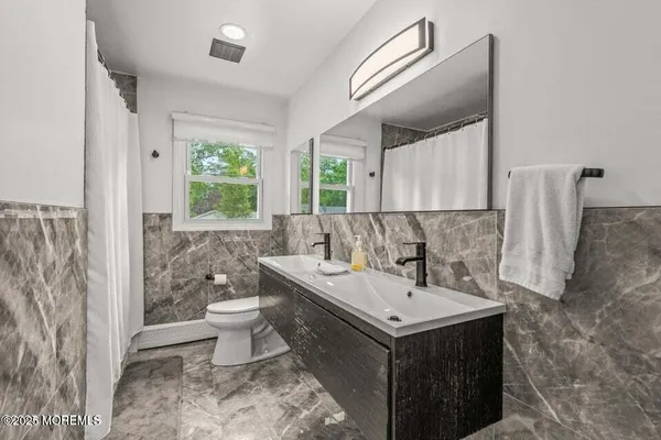 a bathroom with a sink toilet and a mirror