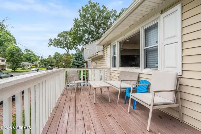 a view of deck with furniture and trees